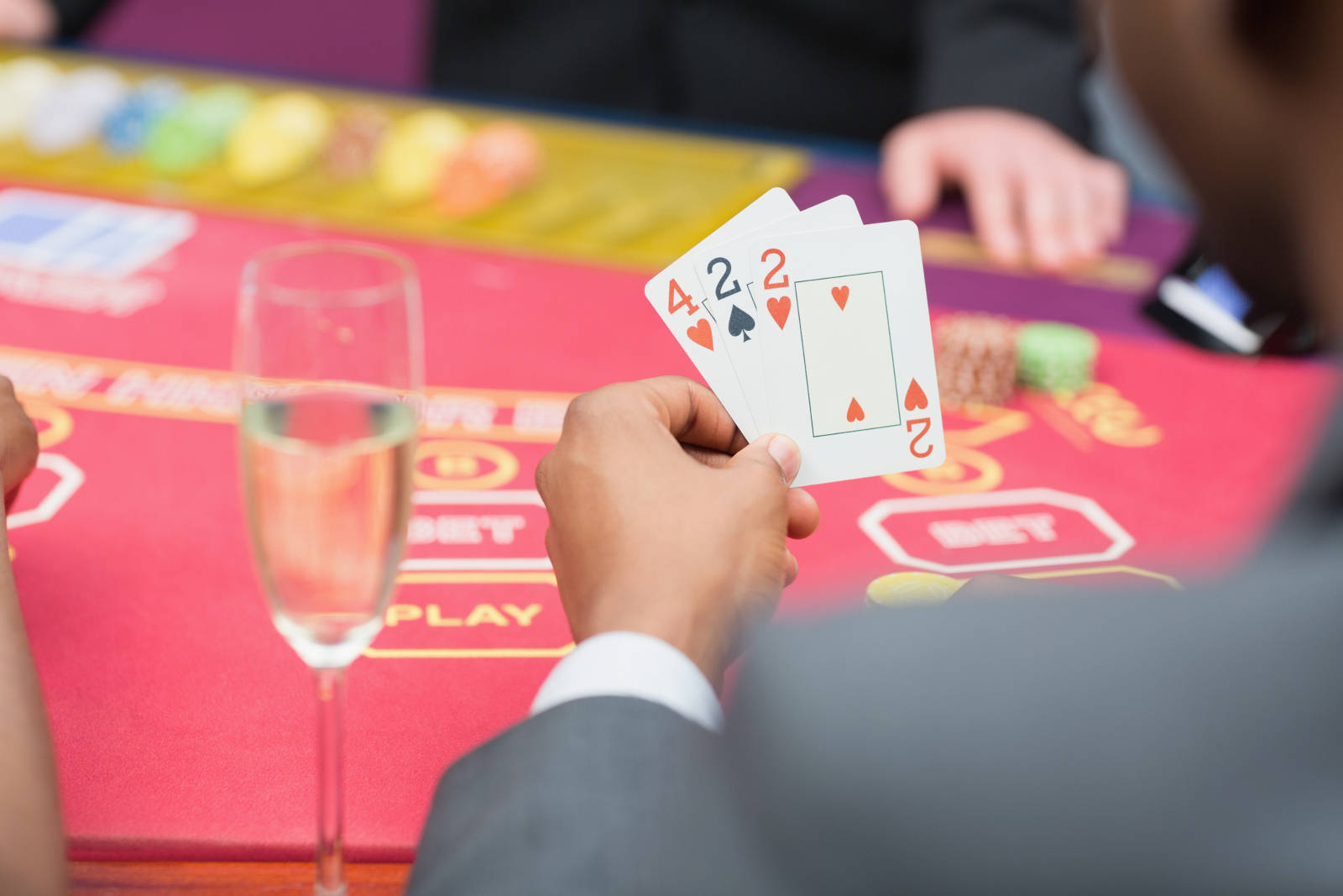 Man holding 3 poker cards