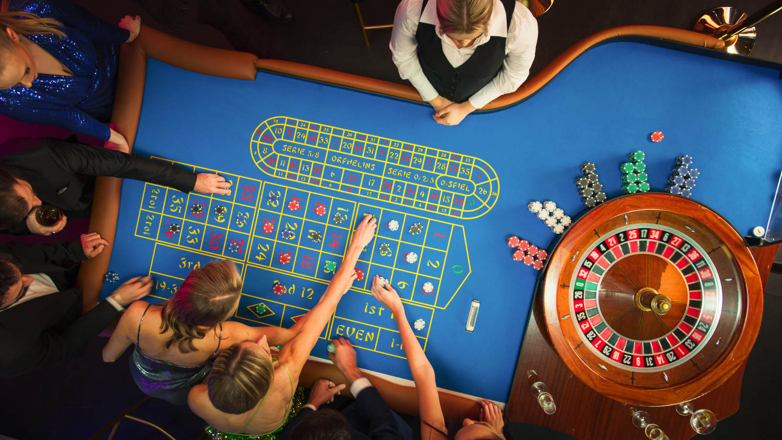 People placing bets at a Roulette table.