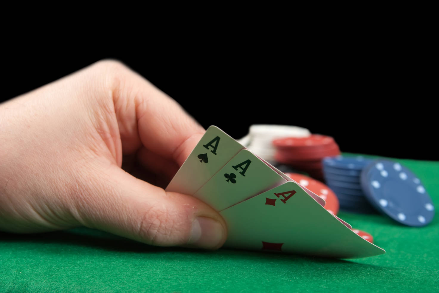 hand holding three playing cards