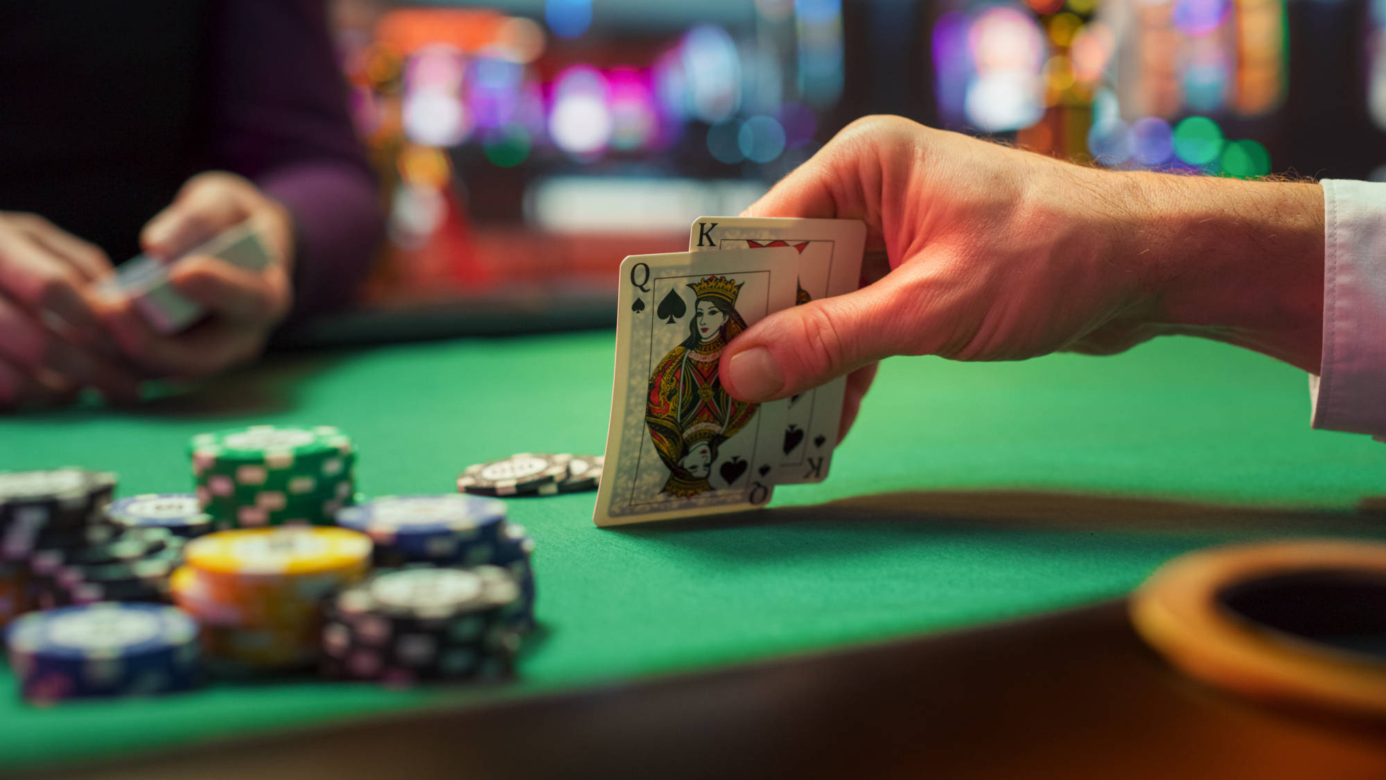 Close Up Shot On Hand of a BlackJack Player Checking Playing Cards He Was Dealt.