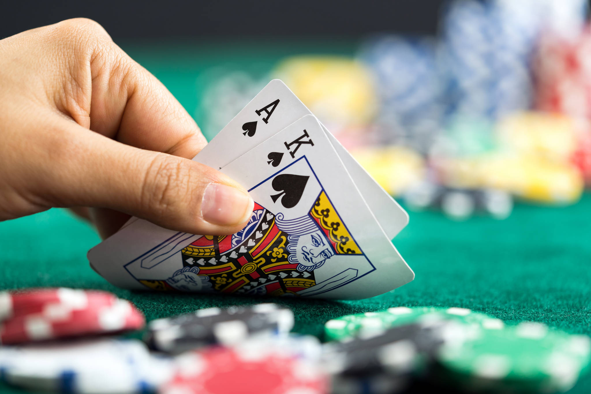 Gambling Hand Holding black jack Cards and Money Coins Chips