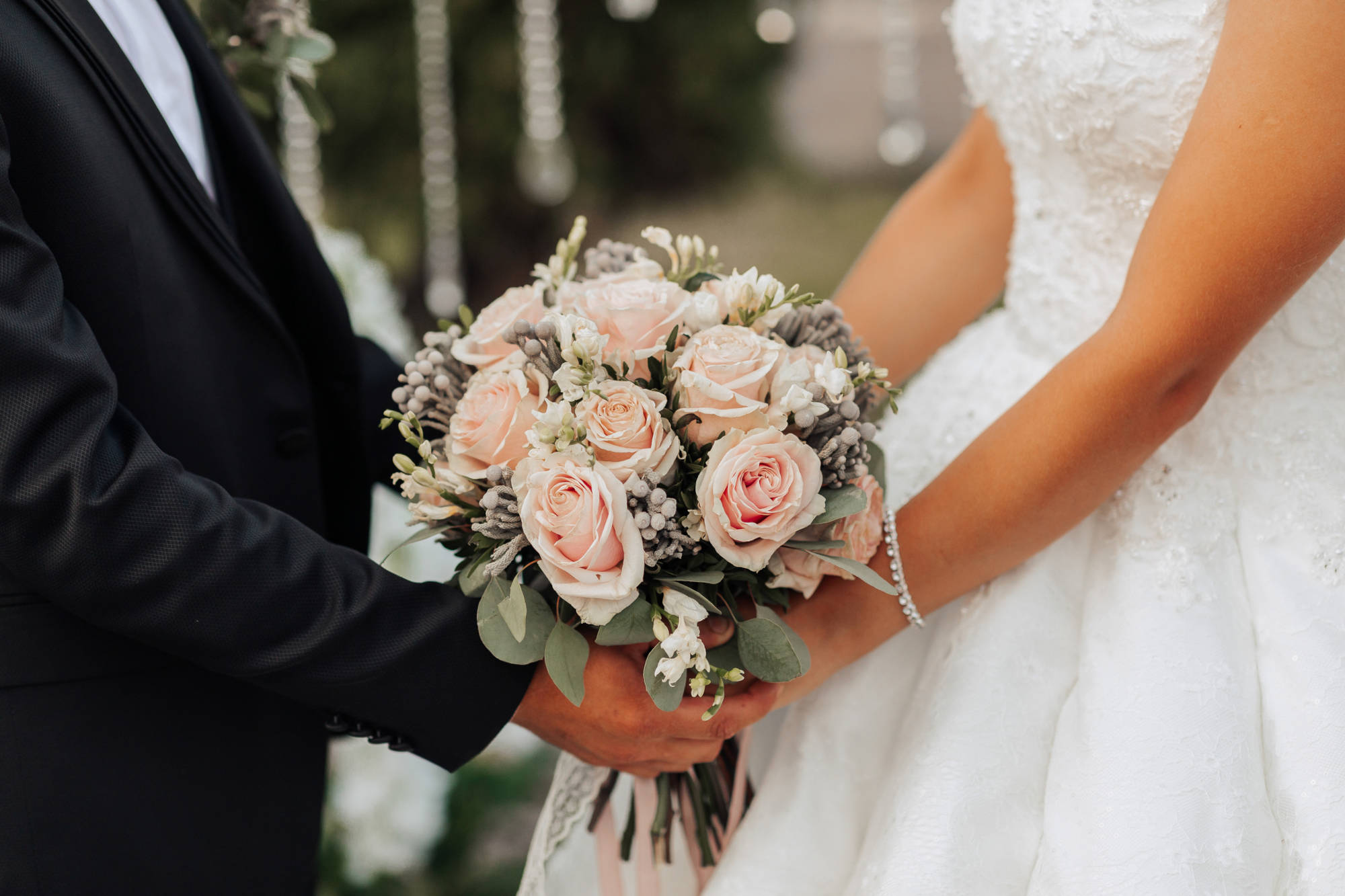 A man and woman are holding a bouquet of flowers